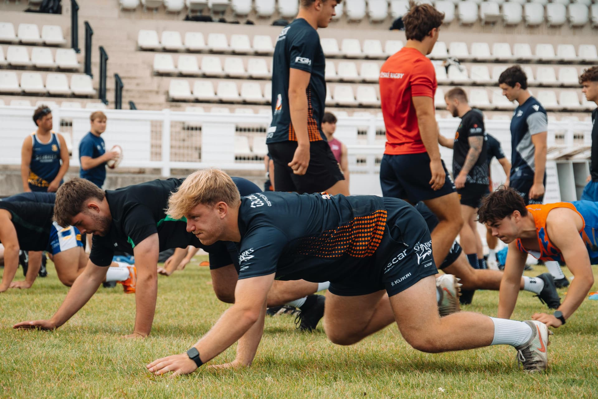 image of a team of football players planning together while kneeling on the grass